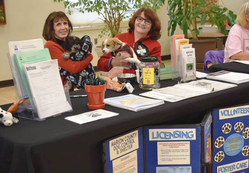 Two women sit at information table