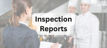 Staff member holding a clipboard reviews information with two kitchen employees in a commercial kitchen, with the text "Inspecti
